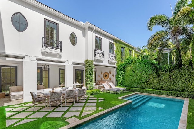 back of house featuring a patio, a balcony, and an outdoor hangout area