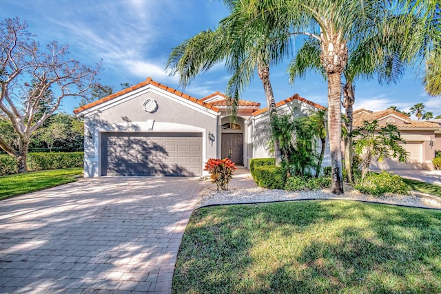 mediterranean / spanish house with a front lawn and a garage