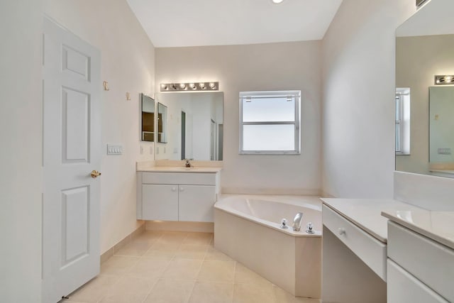 bathroom with vanity, tile patterned flooring, and a tub to relax in