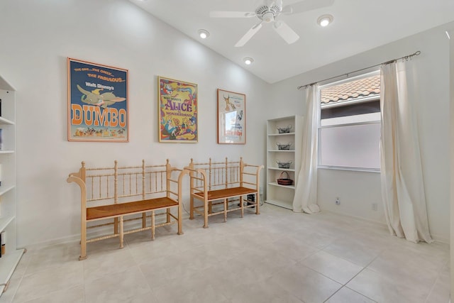 interior space with lofted ceiling, ceiling fan, and light tile patterned floors