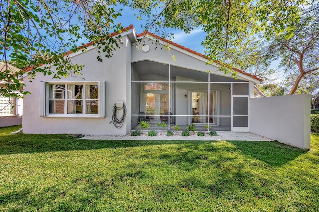 back of house with a yard and a sunroom