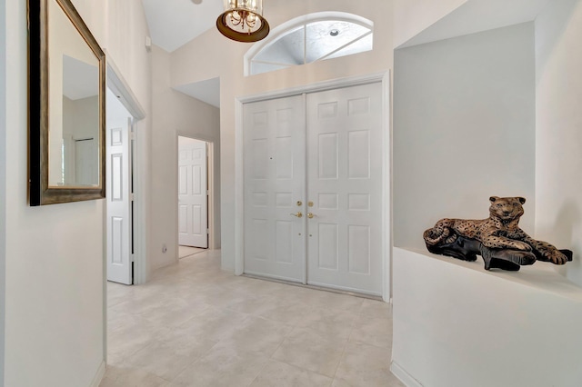 entryway featuring lofted ceiling and a chandelier