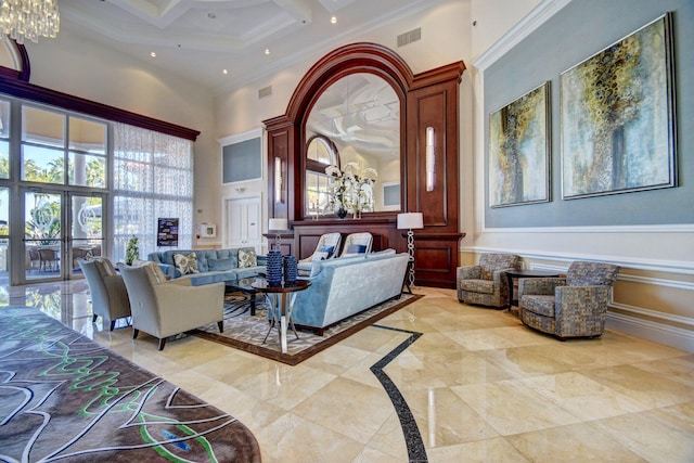 living room with coffered ceiling, beamed ceiling, ornamental molding, a high ceiling, and an inviting chandelier