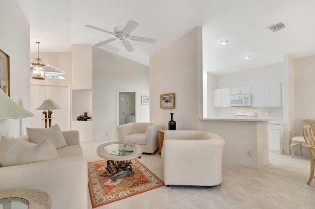 tiled living room with ceiling fan with notable chandelier and high vaulted ceiling