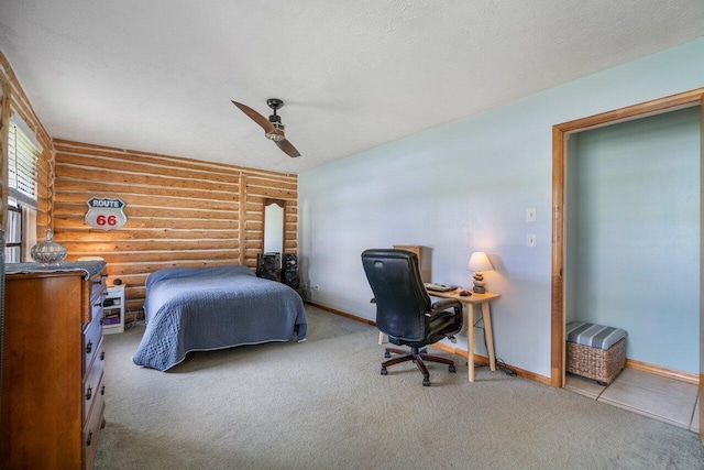 carpeted bedroom featuring ceiling fan and log walls