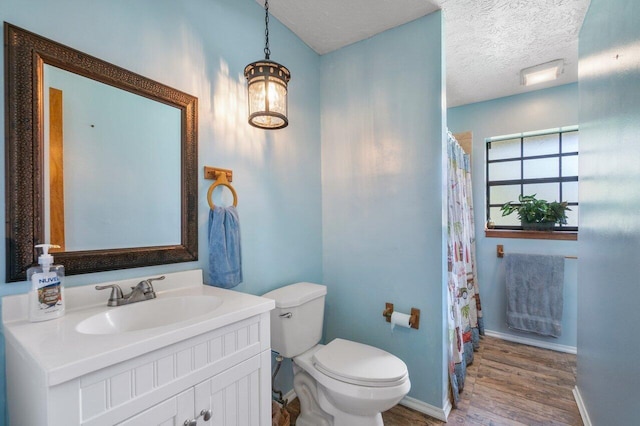 bathroom featuring toilet, vanity, a textured ceiling, and hardwood / wood-style flooring