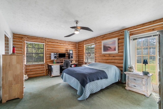 bedroom featuring carpet, ceiling fan, log walls, and a textured ceiling