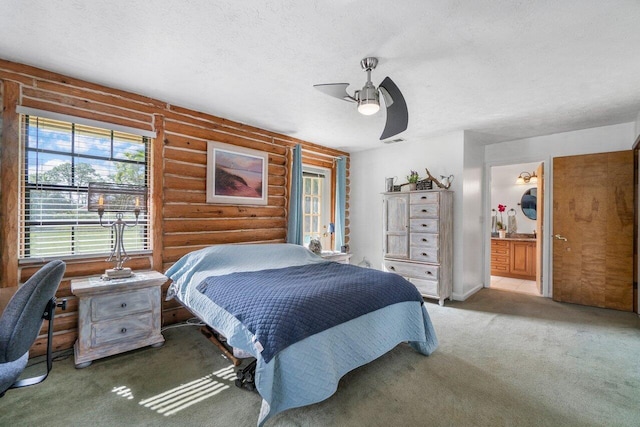 carpeted bedroom with log walls, a textured ceiling, connected bathroom, and ceiling fan