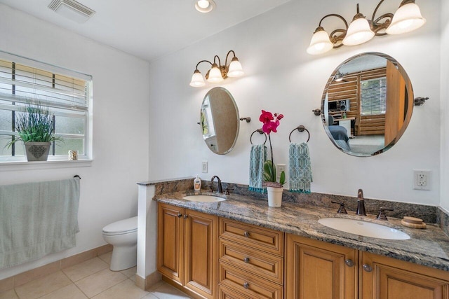 bathroom featuring tile patterned floors, vanity, toilet, and a wealth of natural light