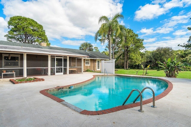 view of swimming pool with a sunroom and a patio