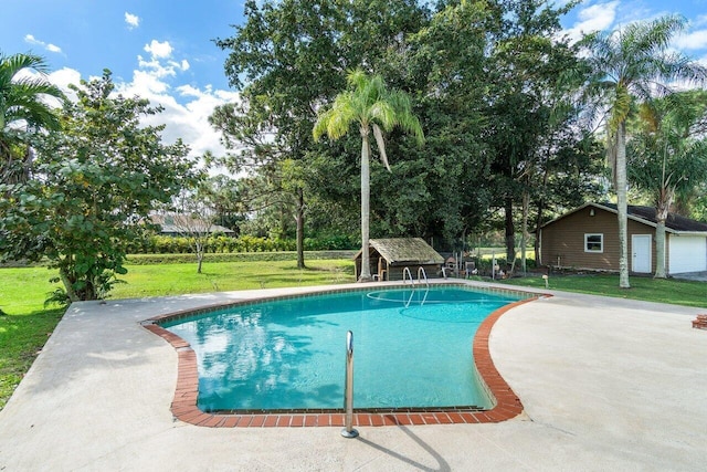 view of swimming pool featuring an outdoor structure, a yard, and a patio