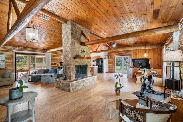 living room featuring vaulted ceiling with beams, light hardwood / wood-style flooring, rustic walls, and wooden ceiling