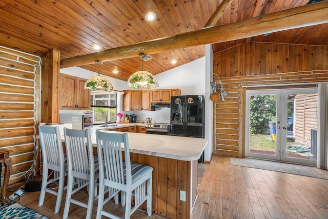 kitchen with log walls, lofted ceiling with beams, kitchen peninsula, and stainless steel range with electric stovetop