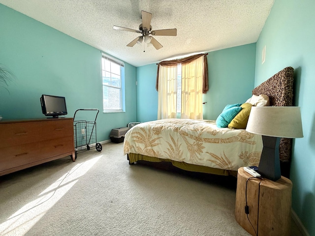 bedroom featuring baseboards, a ceiling fan, a textured ceiling, and light colored carpet