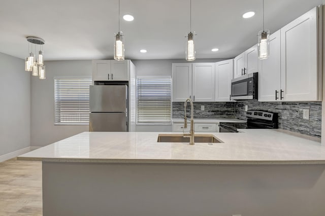 kitchen featuring pendant lighting, sink, white cabinetry, and stainless steel appliances