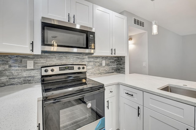 kitchen featuring white cabinets, backsplash, pendant lighting, and stainless steel appliances