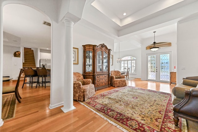 interior space with french doors, light hardwood / wood-style flooring, and ornate columns