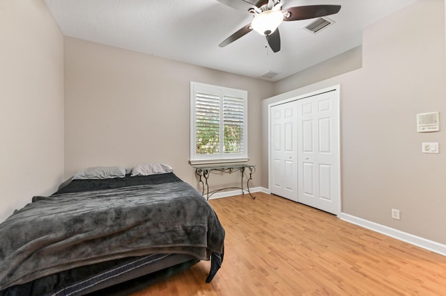 bedroom with ceiling fan, light hardwood / wood-style floors, and a closet