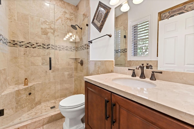 bathroom with vanity, a shower with shower door, and toilet