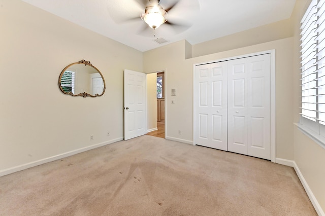 unfurnished bedroom with light carpet, a closet, and ceiling fan