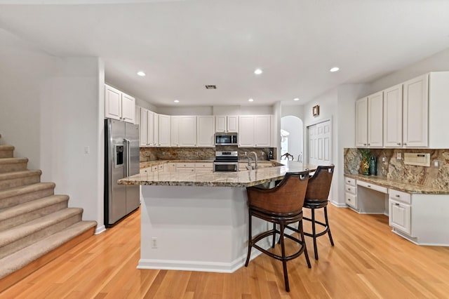 kitchen featuring white cabinetry, appliances with stainless steel finishes, and a center island with sink