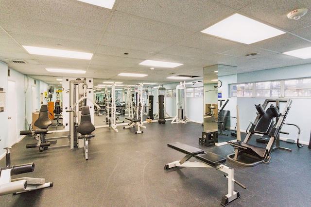 gym featuring a paneled ceiling and a wealth of natural light