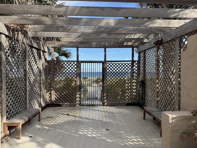 deck with a water view and a pergola