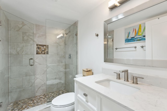 bathroom featuring toilet, vanity, and walk in shower