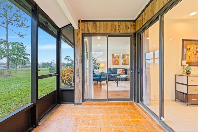 unfurnished sunroom featuring beamed ceiling