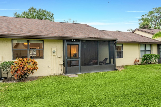 back of property with a lawn and a sunroom