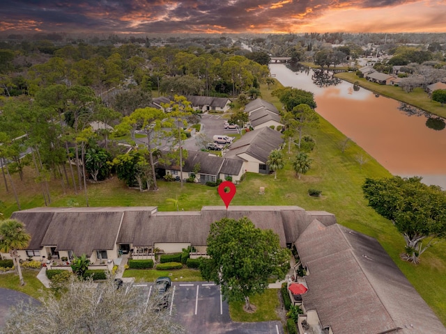 aerial view at dusk featuring a water view