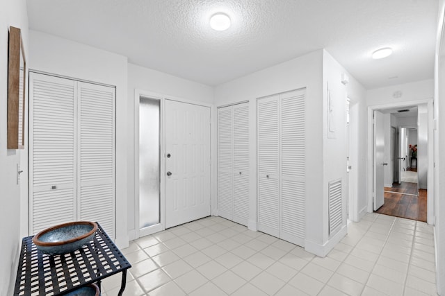 tiled entrance foyer with a textured ceiling