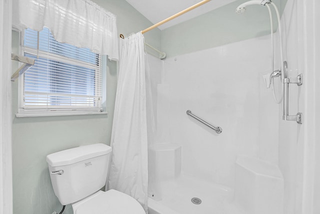 bathroom featuring a shower with curtain and toilet