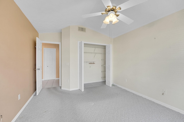 unfurnished bedroom with ceiling fan, lofted ceiling, light carpet, and a closet