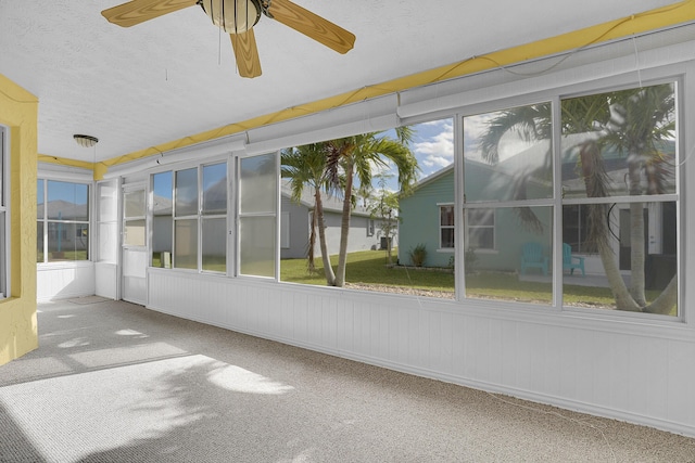 unfurnished sunroom with ceiling fan