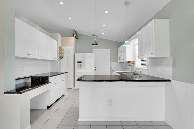 kitchen with white cabinetry, kitchen peninsula, pendant lighting, white appliances, and vaulted ceiling