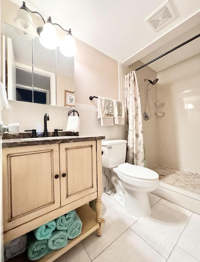 bathroom with a shower with curtain, tile patterned flooring, vanity, and toilet