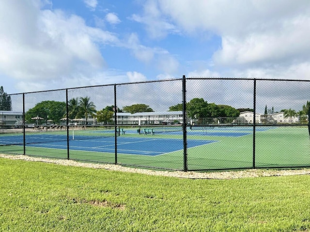 view of tennis court with a yard