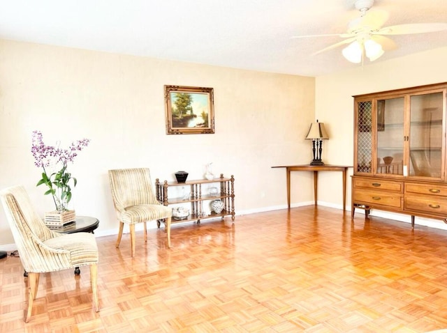 living area featuring ceiling fan and light parquet flooring