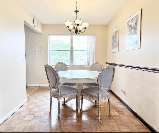 dining room featuring a chandelier and light parquet floors