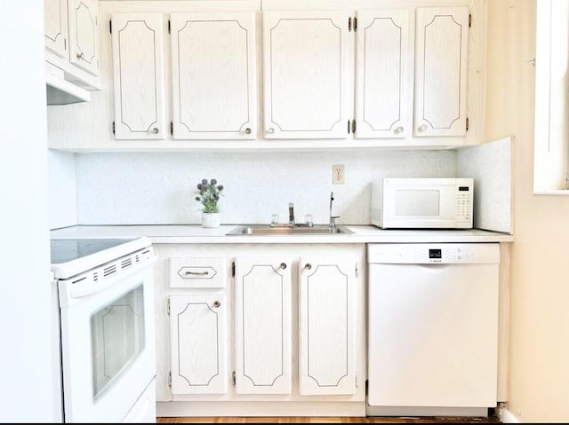 kitchen featuring sink, white cabinets, and white appliances