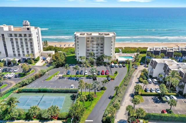 birds eye view of property with a water view and a beach view