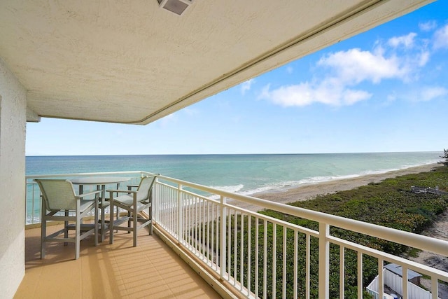 balcony featuring a water view and a beach view