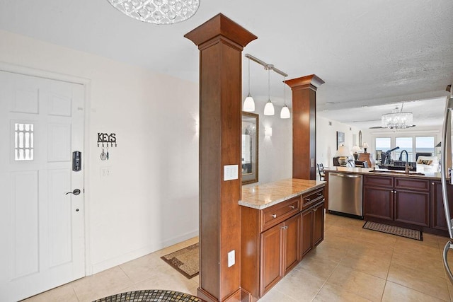 kitchen featuring dishwasher, sink, ornate columns, decorative light fixtures, and light stone counters