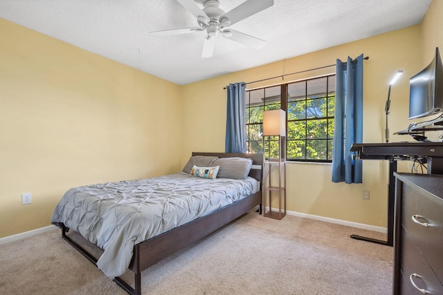 bedroom with light carpet, ceiling fan, and a textured ceiling