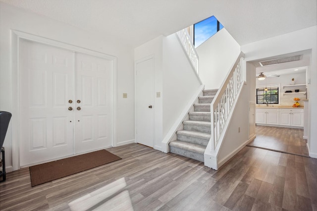 entryway with ceiling fan and light hardwood / wood-style floors