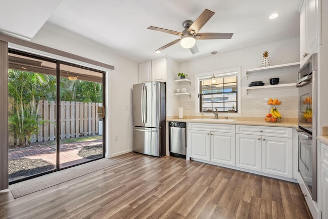 kitchen featuring appliances with stainless steel finishes, white cabinetry, a wealth of natural light, and sink