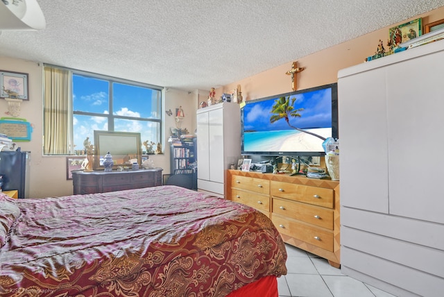 bedroom featuring light tile patterned floors and a textured ceiling