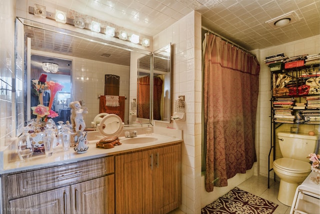 full bathroom featuring vanity, tile patterned flooring, toilet, shower / bath combo with shower curtain, and tile walls