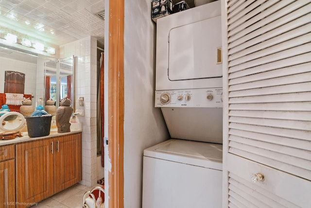 laundry room with light tile patterned floors and stacked washer and clothes dryer